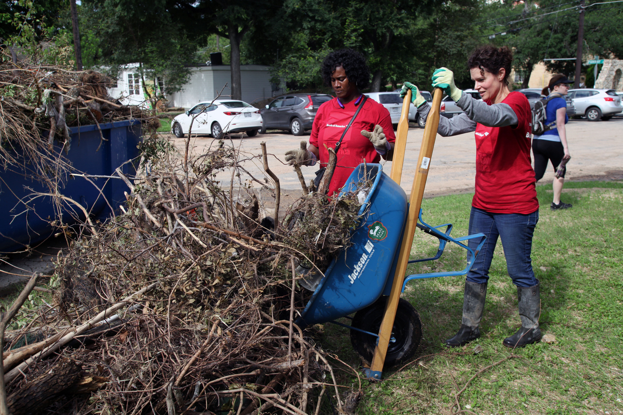 Volunteers removing debris in Pease Park, Austin, Texas, during recovery efforts after the Memorial Day flood, illustrating the importance of knowing how to clean up after a flood.